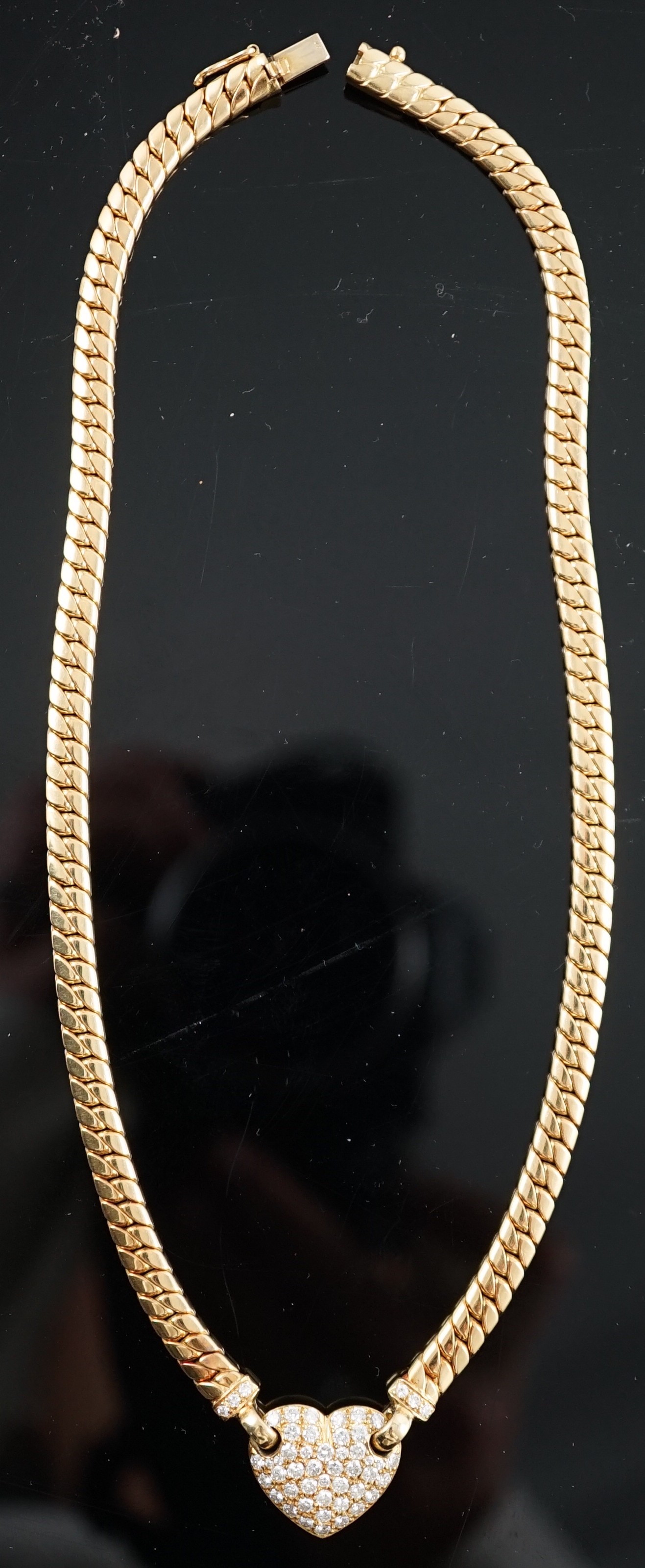 A modern 18ct gold and pave set diamond heart shaped pendant necklace